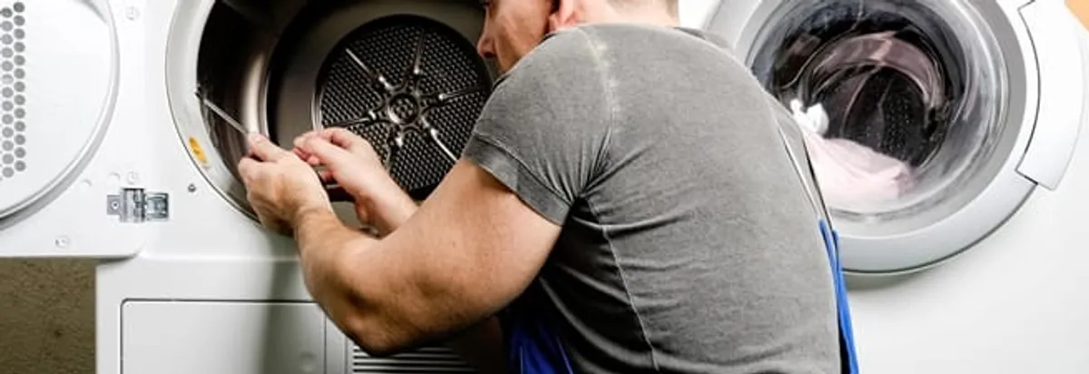 Dryer repair technician fixing a clothes dryer drum in Cape Coral, FL