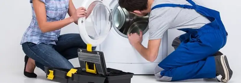 Washer repair technician inspecting a front-load washing machine with tools in Cape Coral, FL